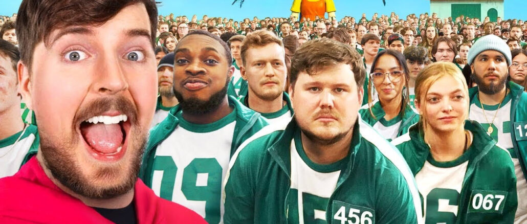 Блогер MrBeast на фоне участников в зеленых костюмах из его видео-реконструкции сериала Игра в кальмара в реальной жизни